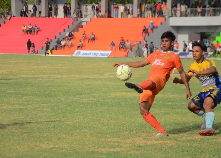 Pemain Tim Muba (orange) saat mengontrol bola dan dibayang-bayangi pemain Palembang, pada semifinal cabor Sepakbola Porprov Sumsel XIII di Stadion Tebat Sari, Kota Martapura, Jumat (26/11/2021). (fornews.co/ist)