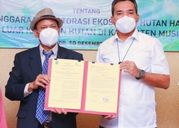 Plt Bupati Beni Hernedi dan Presiden Direktur PT REKI, Mangarah Silalahi menunjukan hasil penandatangan kerja sama penyelenggaraan restorasi ekosistem Hutan Harapan dan Hutan di Luar Kawasan Hutan Kabupaten Muba, di Hotel Grand Savero Bogor, Jawa Barat, Jumat (10/12/2021). (fornews.co/humas pemkab muba)