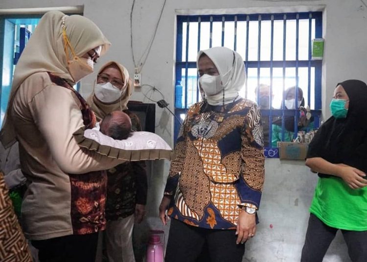 Ketua TP PKK Sumsel, Feby Herman Deru, menggendong bayi dari warga binaan Lapas Perempuan Kelas II A Palembang, Jumat (24/12/2021). (fornews.co/humas pemprov sumsel)