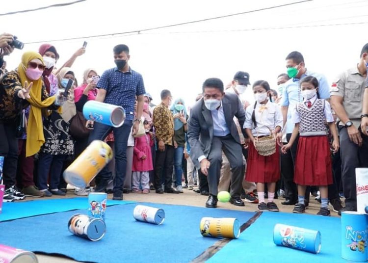 Gubernur Sumsel Herman Deru mencoba permainan masa lalu lempar bola, pada Fesitval Kulintang di Kelurahan Talang Kepu Kecamatan Gandus Palembang, Sabtu (11/12/2021). (fornews.co/humas pemprov sumsel)