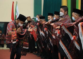 Gubernur Sumsel, Herman Deru, saat dikalungi kain ulos khas Sumatera Utara, usai pelantikan pengurus DPPP dan DPD Permatabagsel di Auditorium Asrama Haji Palembang, Sabtu, (08/01/2022). (fornews.co/humas pemprov sumsel)