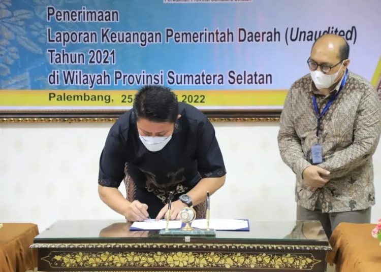 Gubernur Sumsel, Herman Deru menandatangani berita acara, sebelum penyerahan Laporan Keuangan Pemerintah Daerah 2021, di Kantor BPK RI Perwakilan Sumsel, Jumat (25/2/2022). (fornews.co/humas pemprov sumsel)