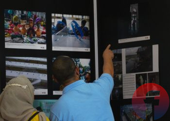 Pengunjung saat memperhatikan foto-foto karya PFI Palembang pada pameran foto Kilas Balik Pameran Foto Jurnalistik 2020/2021, di OPI Mall, Jumat (18/2/2022). (fornews.co/mushaful imam)