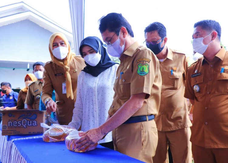 Asisten Setda Muba, Yusuf Amilin bersama Wakil Ketua I TP PKK Muba, Susy Imelda Beni dan Kepala Disdagperin Muba, Azizah, saat memantau operasi pasar minyak goreng di halaman Kantor Desa Air Putih Ulu, Selasa (8/3/2022). (fornews.co/humas pemkab muba)