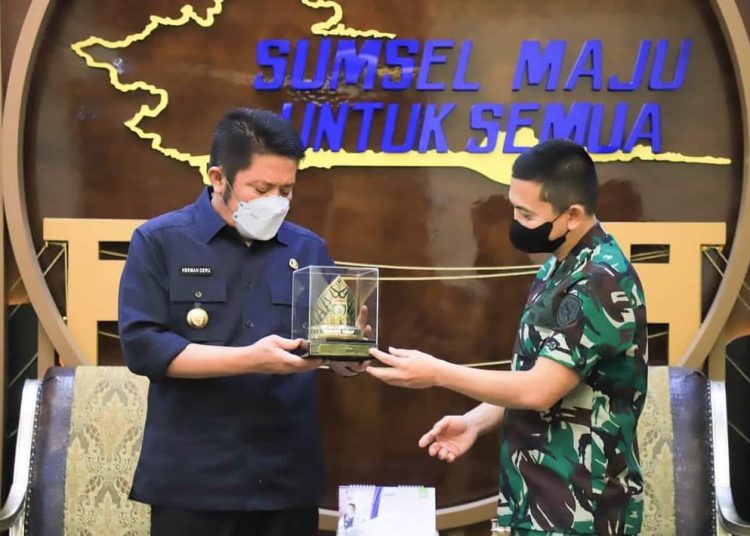 Gubernur Sumsel, Herman Deru saat memberikan cindera mata kepada Danlanal Palembang Kolonel Laut, Widyo Sasongko, di ruang kerja Gubernur, Senin, (04/03/2022). (fornews.co/humas pemprov sumsel)