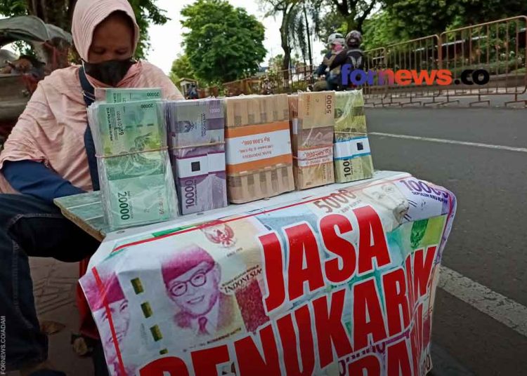 INDAH sedang menunggu lapak penukaran uang di pinggir jalan Senopati. Di tempat ini Indah dan suaminya membuka usaha stempel dan isi ulang gas kaleng. (foto fornews.co/adam)