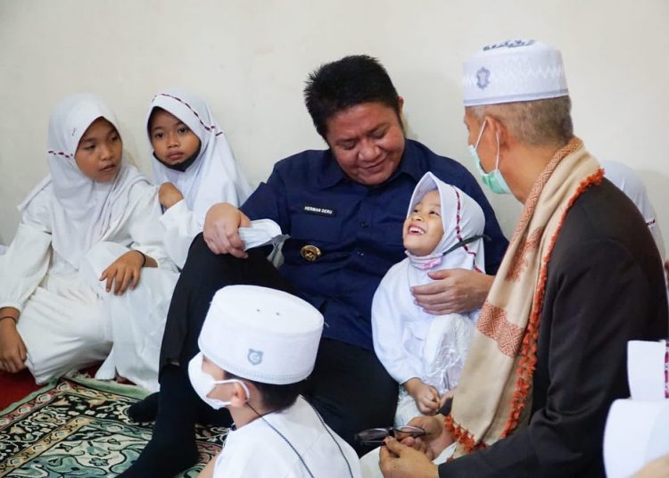 Gubernur Sumsel, Herman Deru bersama AKBP (P) Kahar Muzakir tengah bercengkrama dengan anak-anak, disela-sela peresmian Rumah Alquran Multazam Tahsin dan Tahfidz, di Kelurahan Srijaya, Kecamatan Alang-Alang Lebar, Rabu (27/4/2022). (fornews.co/humas pemprov sumsel)