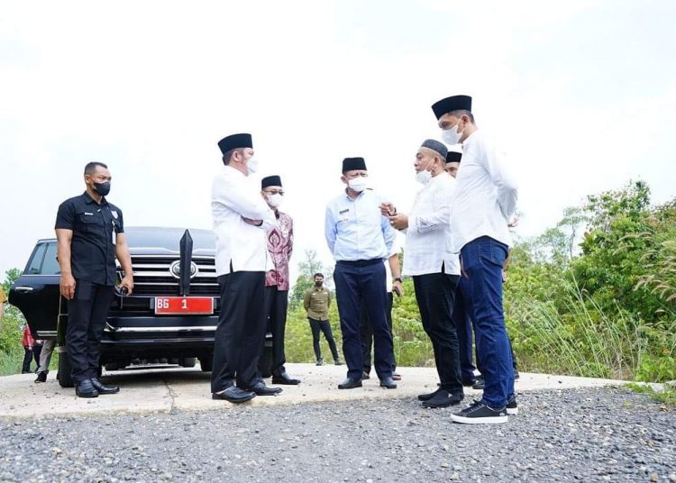 Gubernur Sumsel Herman Deru didampingi Bupati OKU Timur, Lanosin, saat meninjau jalan penghubung Kabupaten OKU Timur di Desa Campang Tiga dan Kabupaten Ogan Ilir di Desa Muara Kuang, Jumat (15/4/2022). (fornews.co/humas pemprov sumsel)