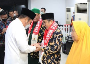 Gubernur Sumsel, Herman Deru melakukan penyematan tanda peserta dan pemasangan syal kepada perwakikan jamaah umrah di Bandara SMB 2 Palembang, Kamis (26/5/2022). (fornews.co/humas pemprov sumsel)  