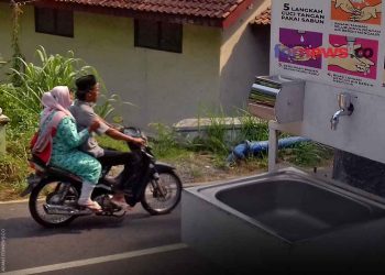SEORANG pengendara berboncengan dengan perempuan yang menggendong bayi melintas di kawasan Candi Borobudur. (foto fornews.co/adam)