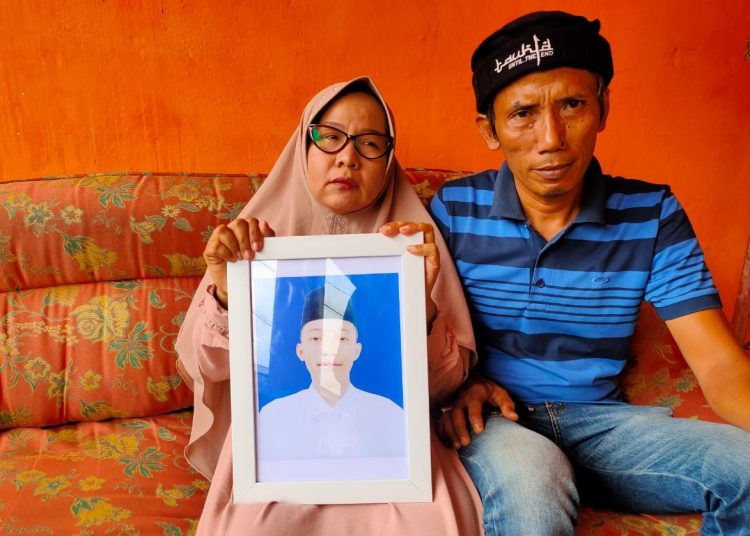 Orang tua Almarhum AM, santri Gontor korban dugaan penganiayaan, Rusdi dan Siti Soimah, menunjukkan foto putra sulungnya semasa hidup. (fornews.co/ist)