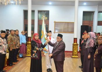 Gubernur Jatim Khofifah Indar Parawansa, saat menyerahkan pataka kepada Pengurus Paguyuban Jatim Sumsel periode 2022-2026, di Griya Agung Palembang, Sabtu (7/1/2023). (fornews.co/humas pemprov sumsel)