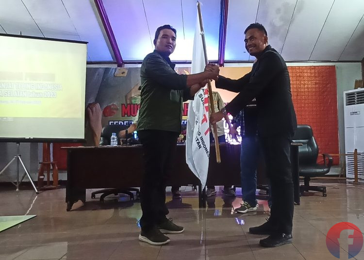Perwakilan PP FPTI, Pontas Sitanggang menyerahkan pataka kepada Ketua terpilih Beni Hernedi, pada Musprov FPTI Sumsel, di Aula KONI Sumsel, Jumat (17/2/2023). (fornews.co/sidratul muntaha)