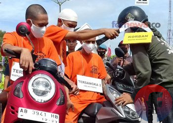 PELAKU saat menganyunkan clurit ke korban. Adegan ini diperagakan dalam rekonstruksi peristiwa beberapa waktu lalu di kawasan Titik Nol Kilometer. (foto fornews.co/adam)
