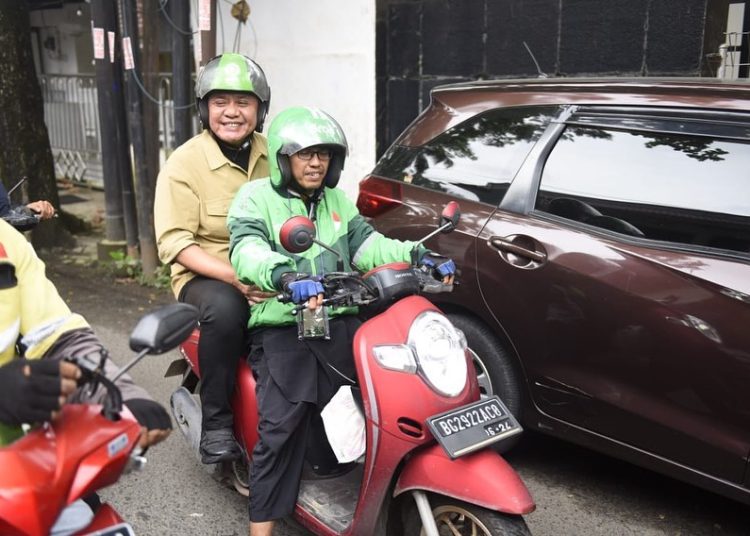 Gubernur Sumsel Herman Deru saat naik motor ojek online menemui para buruh pada aksi damai Hari Buruh di depan Gedung DPRD Sumsel, Senin (1/5/2023). (fornews.co/ist)