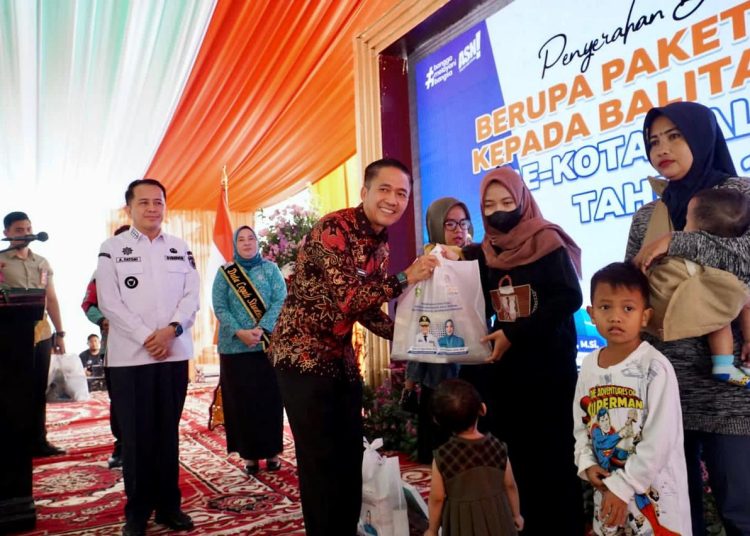 Pj Gubernur Sumsel Agus Fatoni menyaksikan Pj Wako Palembang, Ratu Dewa menyerahkan bansos kepada keluarga penerima manfaat bagi anak stunting di halaman Rumah Dinas Walikota Palembang, Jumat (26/1/2024). (fornews.co/ist)