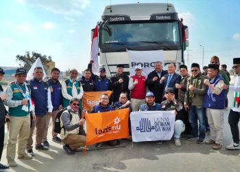 ROMBONGAN Laziizmu dan Poroz di depan truk bantuan dari Indonesia untuk rakyat Palestina. (foto fornews.co/lazismu)