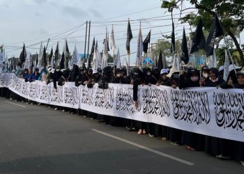 Ratusan orang yang tergabung dalam massa AMP3 saat melakukan long march pada Pawai Isra Mikraj dengan menyerukan pembebasan Palestina, Minggu (2/2/2025). (fornews.co/ist)