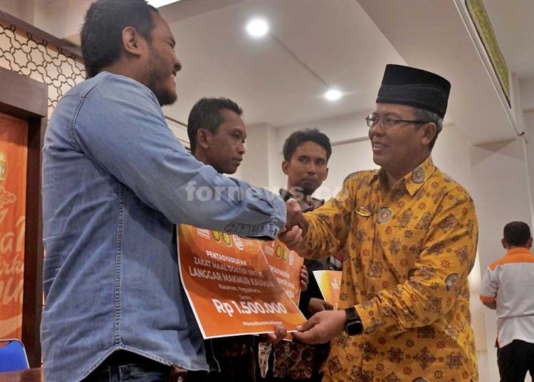 Dr Ihkwan Ahada A.Ag., M.A., selaku Ketua Pimpinan Wilayah Muhammadiyah (PWM) Daerah Istimewa Yogyakarta (DIY) secara simbolis memberikan zakat ma'al dari dokter PKU Muhammadiyah Jogja dan Gamping kepada salah seorang takmir masjid, Jum'at (21/2/2025) di RS PKU Muhammadiyah, Jogja. (foto fornews.co/adam)