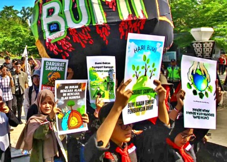 HARI BUMI 2025 puluhan massa di Palembang memperingati Hari Bumi 2025 dengan berjalan kaki sembari  mengangkat bola bumi dari Bundaran Air Mancur menuju Kambang Iwak, Selasa (22/4/2025). (foto fornews.co/sindonews)