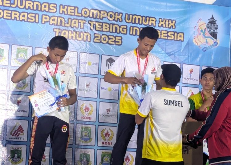 Pelatih Tim Panjat Dinding Sumsel, M Hinayah, mengalungkan medali emas kepada atlet Sumsel, Andicha Pratama, pada Kejurnas Kelompok Umur 2025, di Tangerang, Minggu (22/6/2025). (fornews.co/FPTI Sumsel)