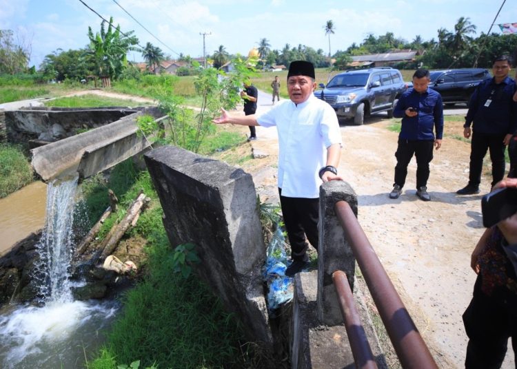 Gubernur Sumsel, Herman Deru, saat melihat kondisi saluran irigasi yang terputus di Desa Sribulan, Kecamatan BP Bangsa Raja Kabupaten OKU Timur, Minggu (13/7/2025). (fornews.co/ist)