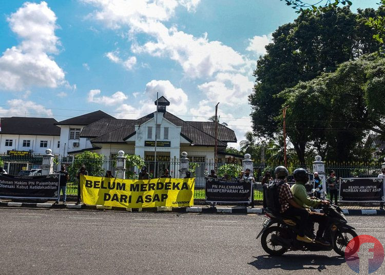 Korban kabut asap dan elemen masyarakat Sumsel dengan berpakaian serba hitam mengekspresikan lewat menggelar aksi tabur bunga di depan PN Palembang, Jumat (4/7/2025). (fornews.co/Mushaful Imam)