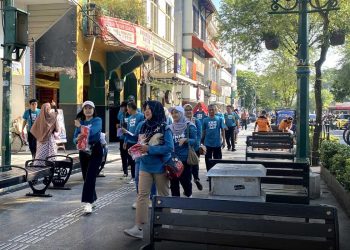SEJUMLAH ASN Diskominfosan berjalan di Malioboro dengan membawa bendera merah putih yang akan dibagikan kepada masyarakat, Jum'at pagi, 1 Agustus 2025. (foto fornews.co/pemkot jogja)