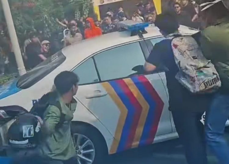 Mahasiswa dan massa yang termasuk pengemudi ojol, melampiaskan amarah mereka dengan merusak mobil patwal polisi, pada aksi di Jakarta, Jumat (29/8/2025). (fornews.co/tangkap layar)