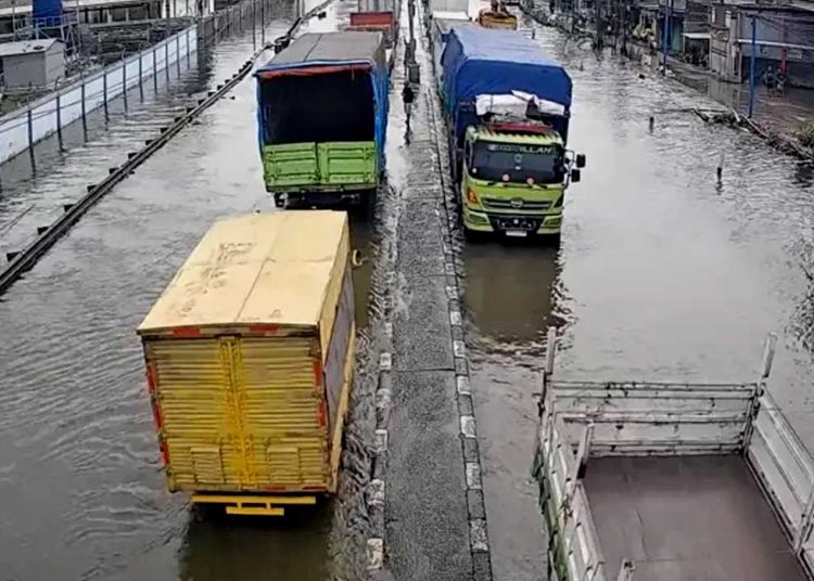 TERENDAM banjir sejumlah truk harus ekstra hati-hati saat melintas di Jalan Demak arah ke Semarang, Selasa, 28 Oktober 2025. (foto fornews.co/mediahub/humas polri)