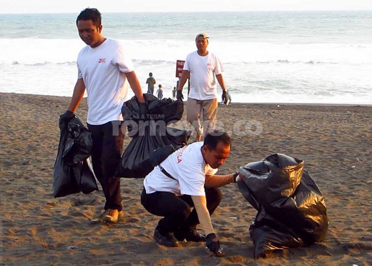 KARYAWAN Loman Park Hotel tampak membersihkan sampah yang terlihat di lokasi Pantai Goa Cemara, Ahad, 12 Oktober 2025. (foto fornews.co/adam)