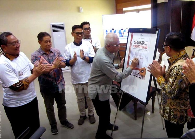KETUA Umum Pimpinan Pusat Muhammadiyah, Prof. Dr. Haedar Nashir, M.Si., secara simbolis menorehkan tanda tangan peluncuran buku "Sengkarut Sengketa Pilkada" karya Irfan Mawardi di PP Muhammadiyah, Jum'at, Desember. (foto fornews.co/adam)