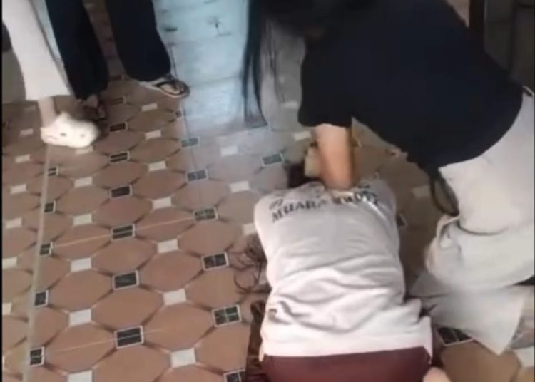 Pelajar inisial NR menarik rambut korban AP di teras rumah warga di Kelurahan Muara Rupit, Kecamatan Rupit, Muratara, pada Sabtu (6/12/2025). (fornews.co/tangkap layar)