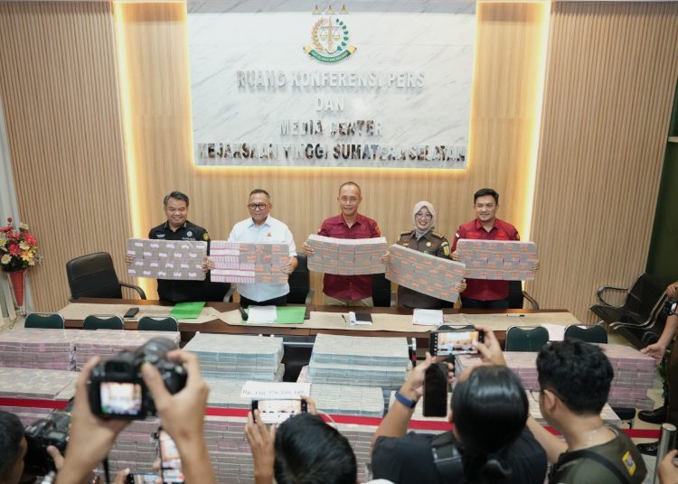 Kajati Sumsel, Dr Ketut Sumedana menunjukan tumpukan uang penitipan pengembalian kerugian keuangan negaradari kasus kredit macet BRI kepada PT BSS dan PT SAL sebesar  Rp110.376.339.349 Kantor Kejati Sumsel, Rabu (7/1/2026). (fornews.co/ist)