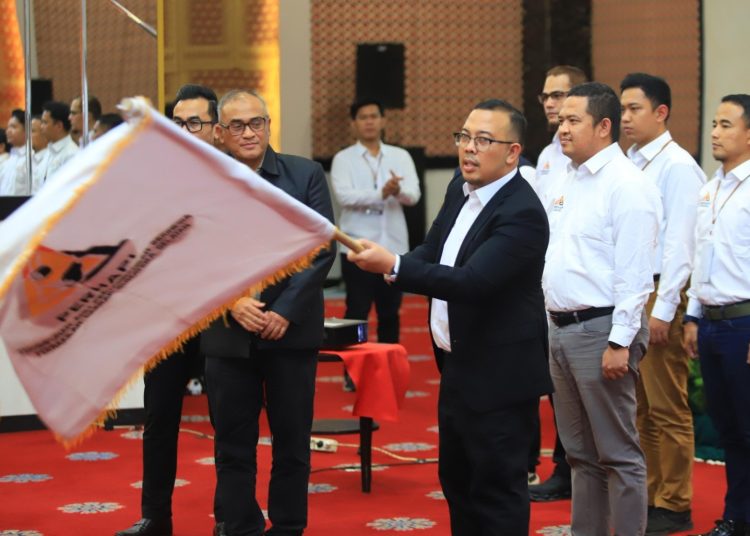 Ketua Perhapi Perwakilan Daerah Sumsel periode 2025–2029, Frans Irawan, mengibarkan pataka dari usai dilantik di Hotel Grand Daira Palembang, Sabtu (31/1/2026). (fornews.co/ist)