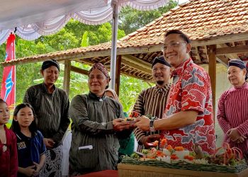 WAKIL Wali Kota Jogja, Wawan Harmawan secara simbolis merima panganan apem dari Ketua Panitia, Herry Santoso Wibowo, mewakili warga kampung Miliran, Muja Muju, Umbulharjo, di kawasan Lahan Laudatosi pada Ahad, 8 Februari.  (foto fornews.co/pemkot jogja)