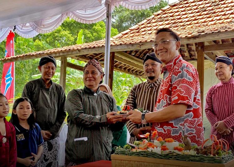 WAKIL Wali Kota Jogja, Wawan Harmawan secara simbolis merima panganan apem dari Ketua Panitia, Herry Santoso Wibowo, mewakili warga kampung Miliran, Muja Muju, Umbulharjo, di kawasan Lahan Laudatosi pada Ahad, 8 Februari.  (foto fornews.co/pemkot jogja)