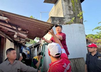 WALI Kota Jogja, Hasto Wardoyo, tampak ikut menurunkan asbes dari atap rumah Maryadi yang masuk kategori Rumah Tidak Layak Huni (RTLH), Ahad pagi, 8 Februari. (foto fornews.co/pemkot jogja)
