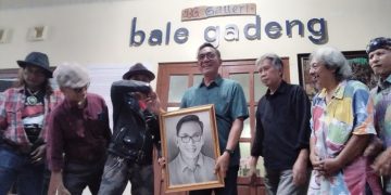 WAWAN Hermawan, Wakil Wali Kota Jogja, menerima kenang-kenangan berupa lukis wajah Agus Dancer perupa Jogja. (foto fornews.co/adam)