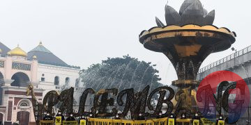 Relawan Tim Cegah Api, saat mengirim pesan 'Belum Merdeka dari Asap' dan 'Udara Bersih adalah Hak' di depan Jembatan Ampera, pada Rabu, (7/10/2026). (fornews.co/foto: Mushaful Imam)