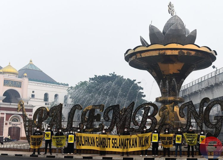 Relawan Tim Cegah Api, saat mengirim pesan 'Belum Merdeka dari Asap' dan 'Udara Bersih adalah Hak' di depan Jembatan Ampera, pada Rabu, (7/10/2026). (fornews.co/foto: Mushaful Imam)